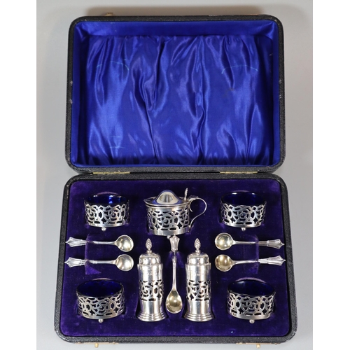 41 - George V silver filigree condiment set comprising: four silver salts, two silver pepperettes, mustar... 