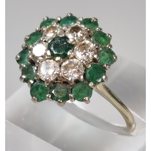 54 - 18ct white gold flowerhead cluster ring inset with thirteen emeralds and six diamonds. 4.8g approx. ... 