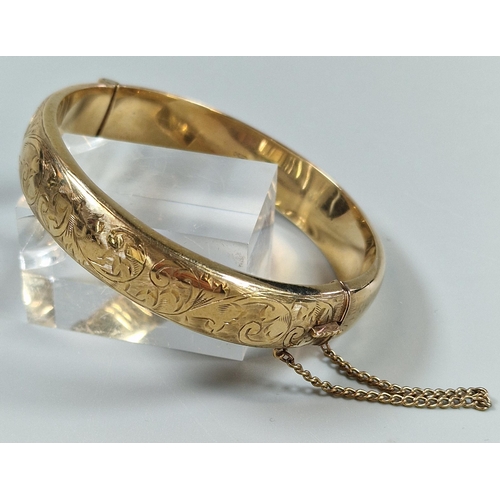 84 - 9ct gold engraved bangle. 6.5cm diameter approx. 18g approx.   (B.P. 21% + VAT)