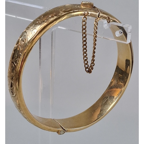 84 - 9ct gold engraved bangle. 6.5cm diameter approx. 18g approx.   (B.P. 21% + VAT)