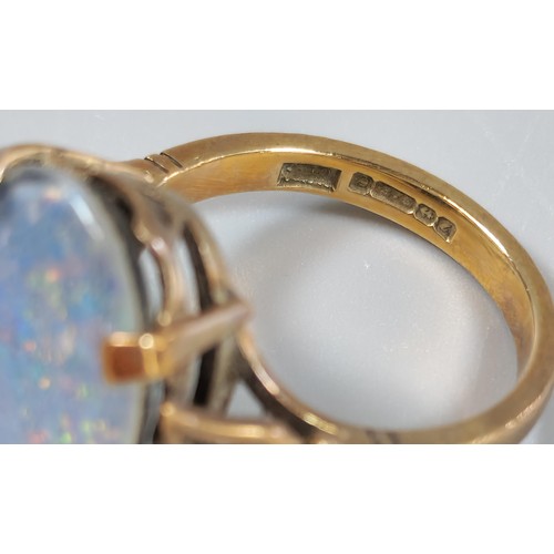 63 - 9ct gold ring inset with large opal cabochon stone, 1.8x1.1cm approx. 5.4g approx. Size M1/2. (B.P. ... 