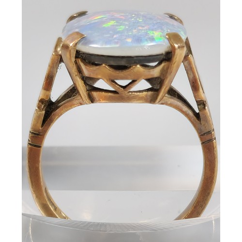 63 - 9ct gold ring inset with large opal cabochon stone, 1.8x1.1cm approx. 5.4g approx. Size M1/2. (B.P. ... 