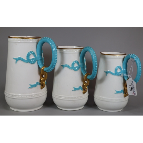 179 - Set of three Victorian porcelain graduated jugs, having gilt rims and turquoise handles with relief ... 