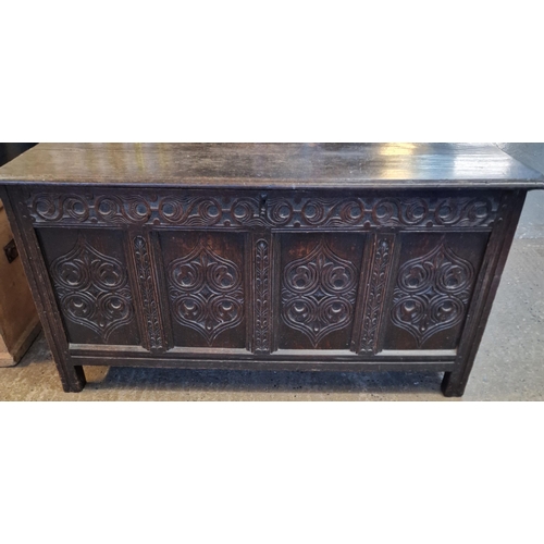 563 - 18th century oak panelled coffer, the moulded hinged lid above pierced frieze with four ornately car... 