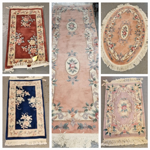 587 - Collection of five small Chinese floral and foliate wash ground rugs of rectangular and oval form, t... 