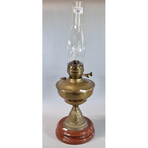 83 - Early 20th century double oil burner lamp, having brass reservoir on brass and ceramic moulded base.... 