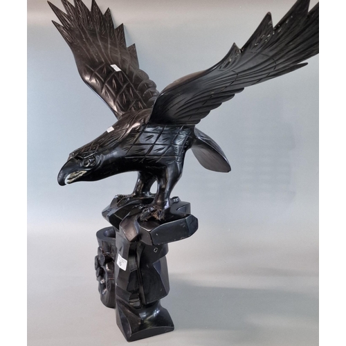 85 - Carved hardwood study of an eagle with out-stretched wings on a naturalistic tree stump. 85cm wide a... 