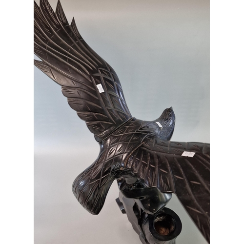 85 - Carved hardwood study of an eagle with out-stretched wings on a naturalistic tree stump. 85cm wide a... 