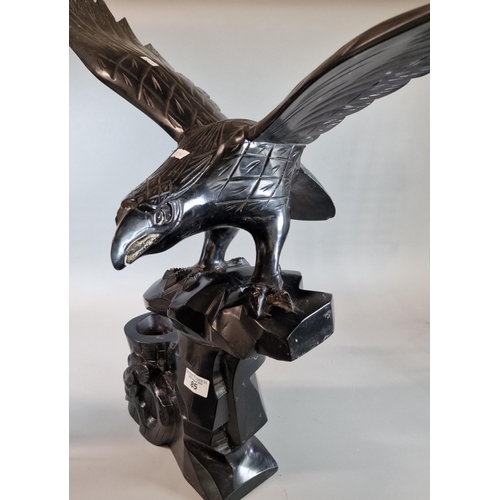 85 - Carved hardwood study of an eagle with out-stretched wings on a naturalistic tree stump. 85cm wide a... 