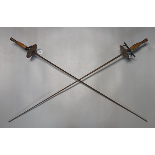 194 - Pair of fencing foils with chequered wooden grips. (2)  (B.P. 21% + VAT)