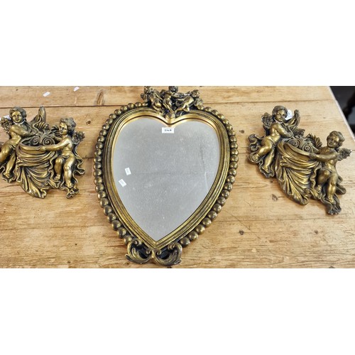 514A - Modern gilt framed heart shaped beaded mirror with cherubs together with a pair of gilded compositio... 