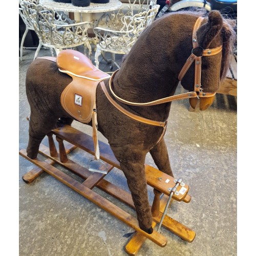 590 - Mid 20th century child's upholstered rocking horse on swing frame base. Bearing label to leather sad... 