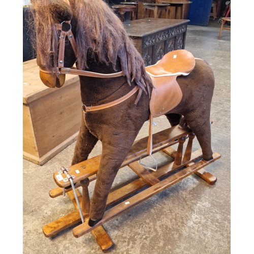 590 - Mid 20th century child's upholstered rocking horse on swing frame base. Bearing label to leather sad... 