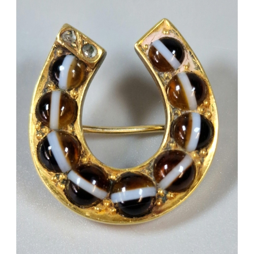 291 - Victorian yellow metal and agate brooch in the form of a horse shoe, inset with two tiny diamond chi... 