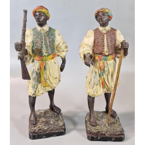 52 - Pair of spelter polychrome decorated Blackamoor figures, one with rifle, one with a staff. 24cm high... 