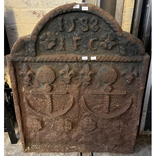 550 - 16th century style cast iron arched fire back bearing nautical and Fleur de Lys motifs and date 1583... 