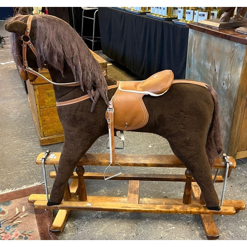 551 - Mid 20th century child's upholstered rocking horse on swing frame base. Bearing label to leather sad... 