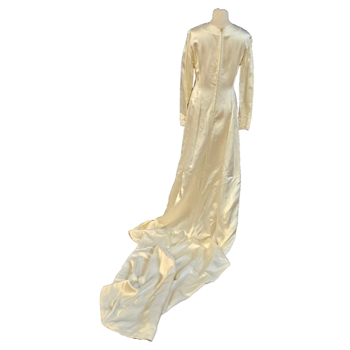 586 - circa 1960s long trained wedding gown of ivory sateen. Cuffs and front panel with self-coloured gilt... 