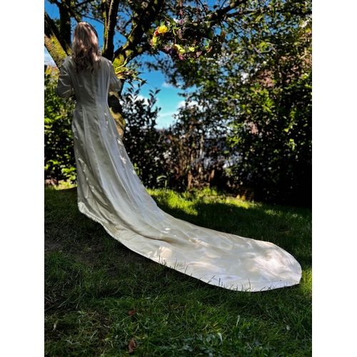 586 - circa 1960s long trained wedding gown of ivory sateen. Cuffs and front panel with self-coloured gilt... 