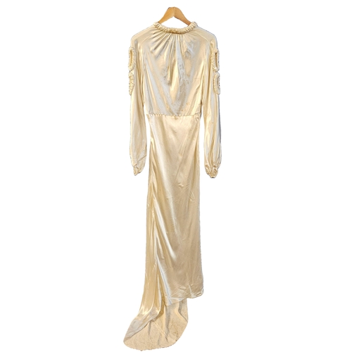 586 - circa 1960s long trained wedding gown of ivory sateen. Cuffs and front panel with self-coloured gilt... 