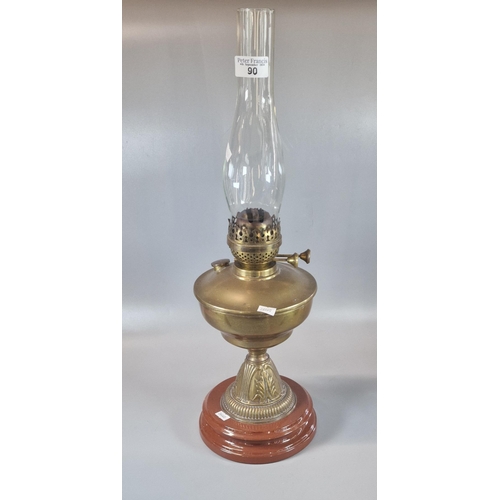 90 - Early 20th century double oil burner lamp, having brass reservoir on brass and ceramic moulded base.... 