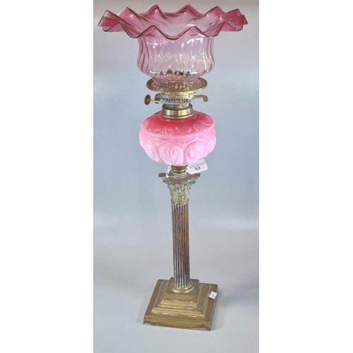 93 - Early 20th century double oil burner lamp, having frilled cranberry glass shade above a pink ceramic... 