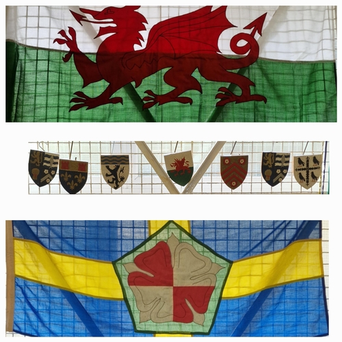 114 - Large linen flag of Wales together with similar Pembrokeshire and a group of woodpecker carved woode... 