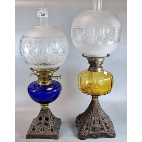 201 - Two early 20th century double oil burner lamps, both having globular etched shades above blue and or... 