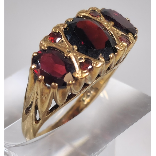 299 - 9ct gold three stone garnet dress ring. 4.1g Size N1/2. (B.P. 21% + VAT)