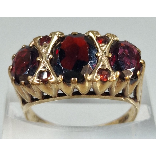 299 - 9ct gold three stone garnet dress ring. 4.1g Size N1/2. (B.P. 21% + VAT)