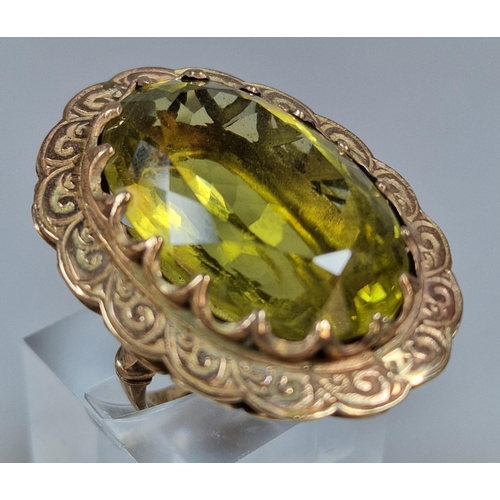 311 - 9ct gold green stone dress ring of large oval form. 21.5g approx. Size L1/2. (B.P. 21% + VAT)