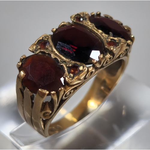 316 - 9ct gold garnet three stone dress ring. 4.1g approx. Size N1/2. (B.P. 21% + VAT)