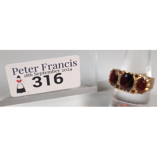 316 - 9ct gold garnet three stone dress ring. 4.1g approx. Size N1/2. (B.P. 21% + VAT)