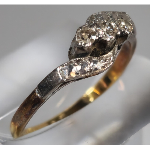 329 - 18ct gold and platinum diamond three stone twist shank ring. 2.3g approx. Size N. (B.P. 21% + VAT)