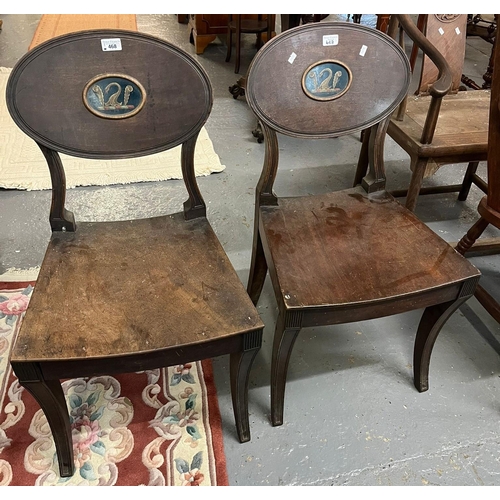 468 - Pair of 19th century Regency mahogany panel backed hall chairs with oval armorial, solid seat on sab...