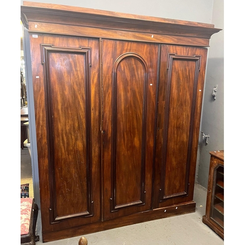 513 - Victorian mahogany three section wardrobe having moulded cornice above three blind panelled doors re... 