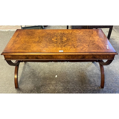 537 - Good quality reproduction walnut coffee table on X frame end supports. Labelled Gwylim Price and Son... 