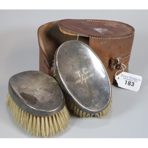 183 - Pair of silver topped travelling brushes in fitted leather case. Marked TC 1899-1924.  (B.P. 21% + V... 