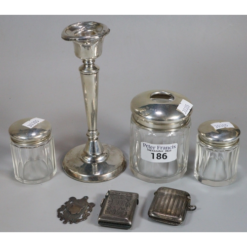 186 - Plastic box of assorted silver items to include: single candlestick with loaded base, dressing table... 