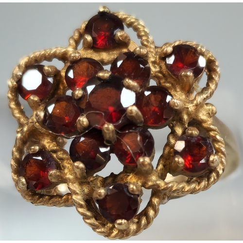 198 - 9ct gold garnet multi cluster flowerhead ring. 4.1g approx. Size K. (B.P. 21% + VAT)