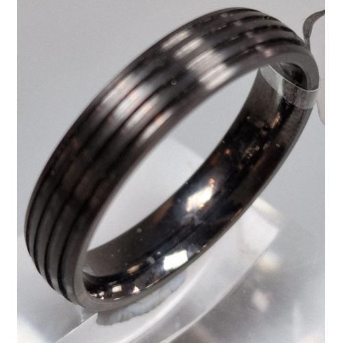 218 - Modernist titanium ring of ribbed form. In ring box. Size T. (B.P. 21% + VAT)