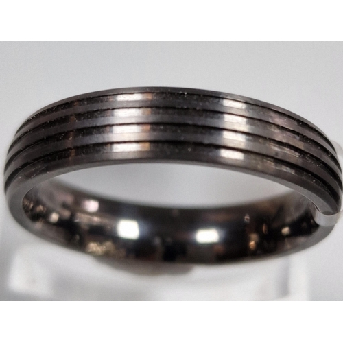 218 - Modernist titanium ring of ribbed form. In ring box. Size T. (B.P. 21% + VAT)