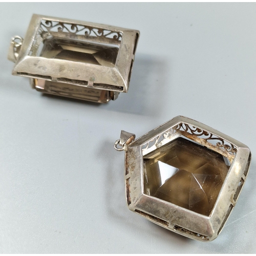 236 - Two similar brown stone faceted pendants in white metal mounts. (B.P. 21% + VAT)