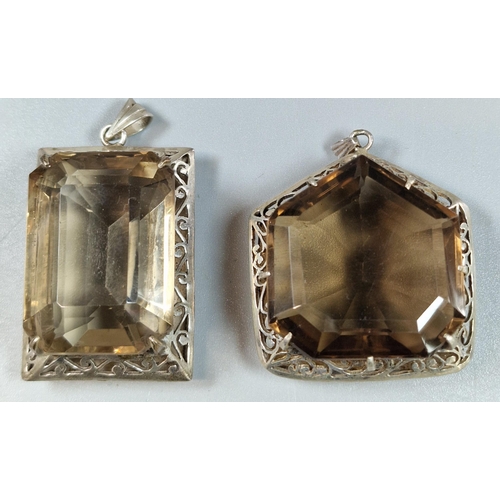 236 - Two similar brown stone faceted pendants in white metal mounts. (B.P. 21% + VAT)