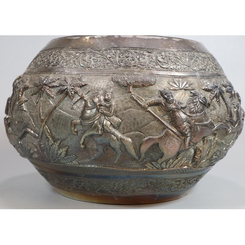 276 - Indian/Burmese circular bowl, chased in bold relief with a hunting party under attack with various a... 