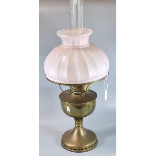 59 - Early 20th century oil burner lamp having pink glass fluted shade above a brass reservoir and base. ... 