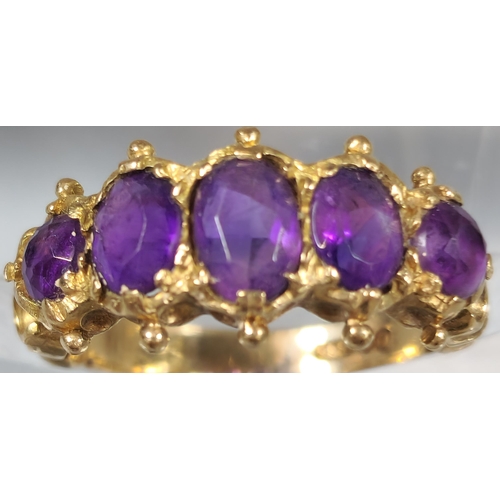 197 - 9ct gold five stone purple dress ring. 3.1g approx. Ring size J. (B.P. 21% + VAT)