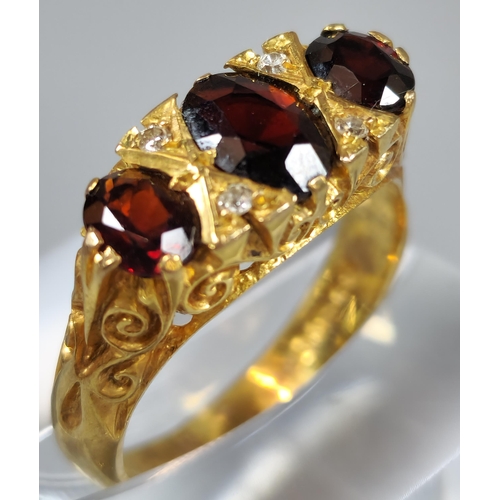 198 - 9ct gold three stone garnet and diamond dress ring. 4.3g approx. Ring size O 1/2. (B.P. 21% + VAT)