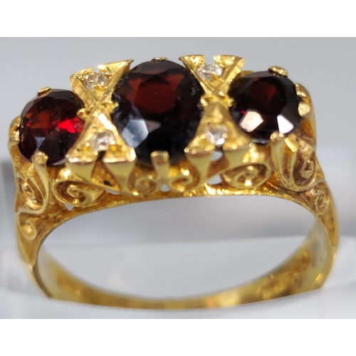 198 - 9ct gold three stone garnet and diamond dress ring. 4.3g approx. Ring size O 1/2. (B.P. 21% + VAT)