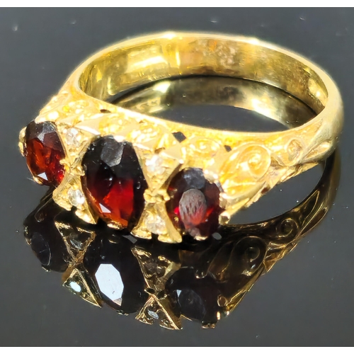 198 - 9ct gold three stone garnet and diamond dress ring. 4.3g approx. Ring size O 1/2. (B.P. 21% + VAT)